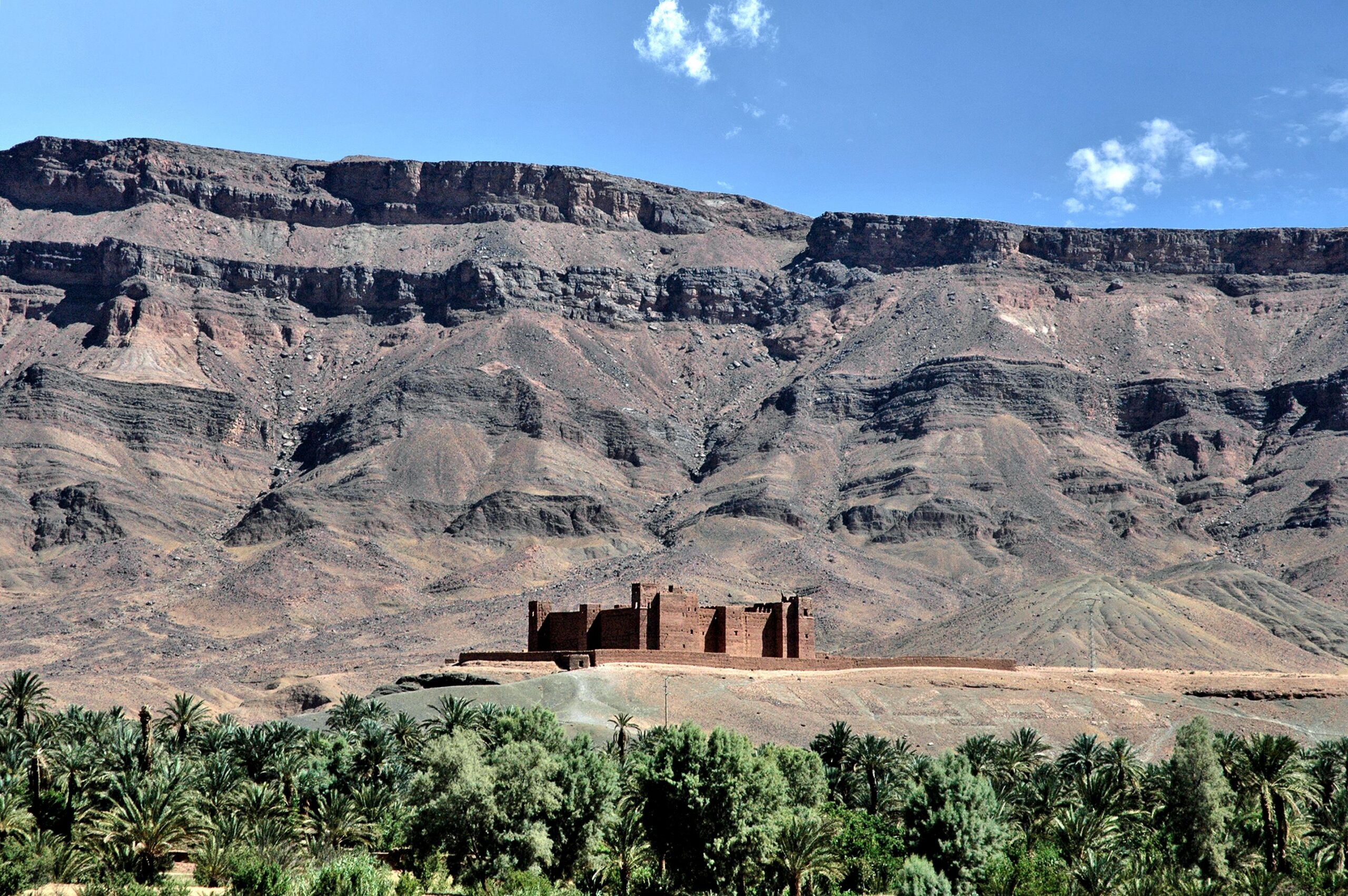 Stunning view of a traditional kasbah in Zagora set against rugged mountains, Morocco.