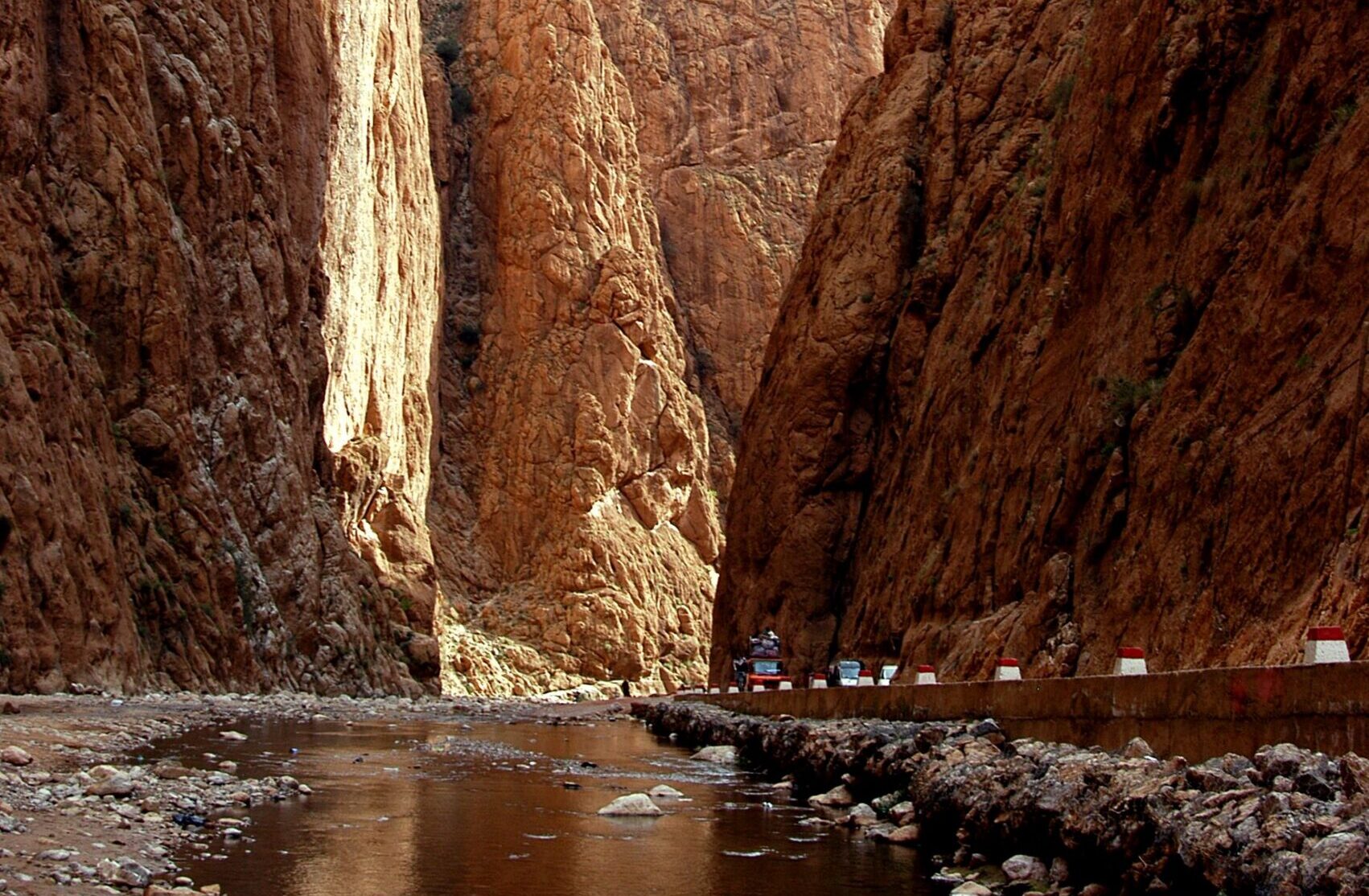 Captivating view of Todra Gorge's towering cliffs and tranquil stream in Tinghir, Morocco.