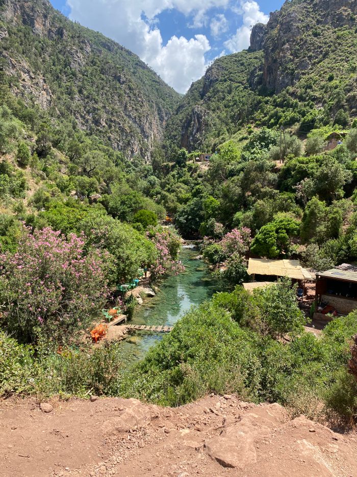Scenic view of a lush green valley with a river running through, surrounded by mountains.