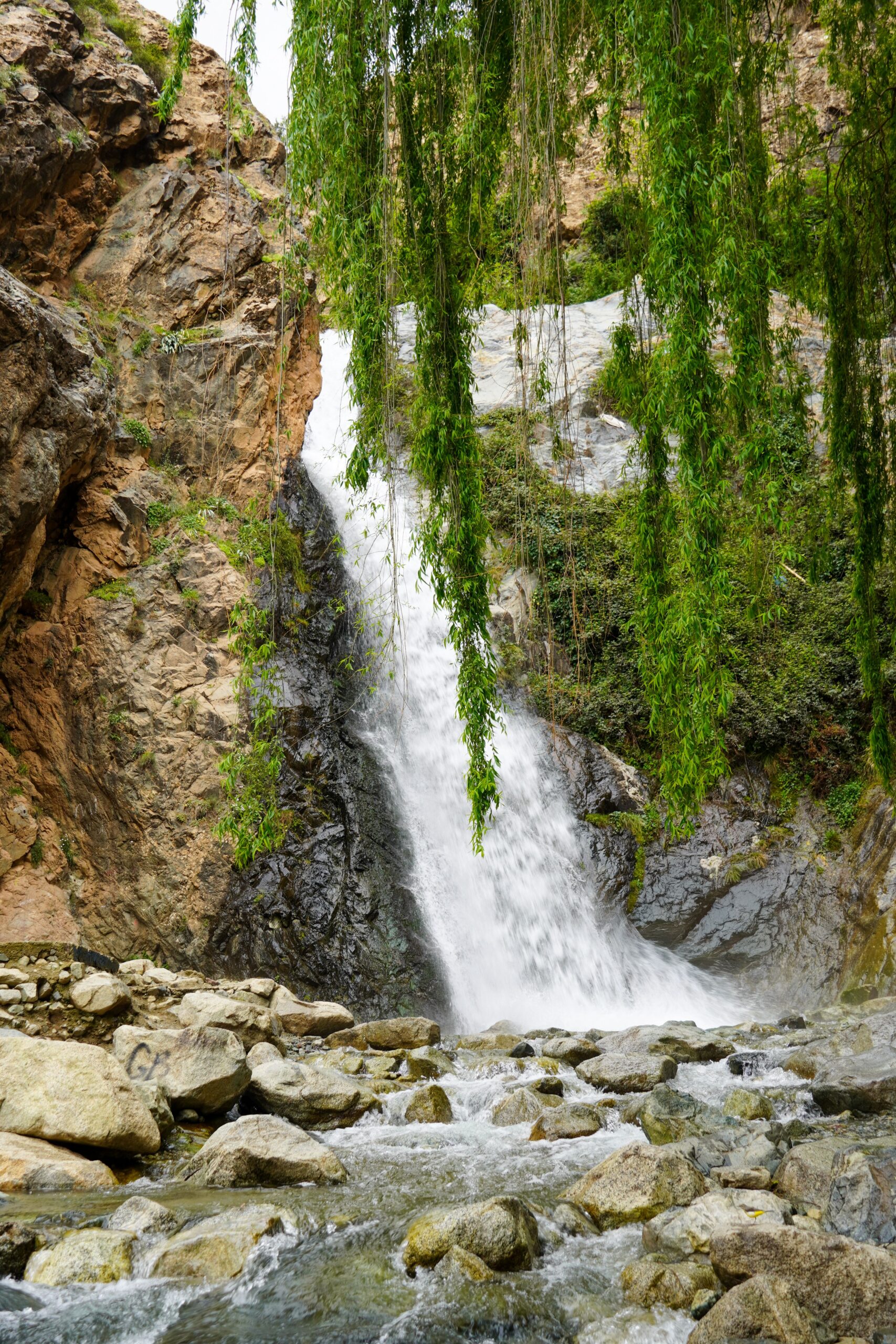 Beautiful waterfall cascading over rocks surrounded by lush greenery.