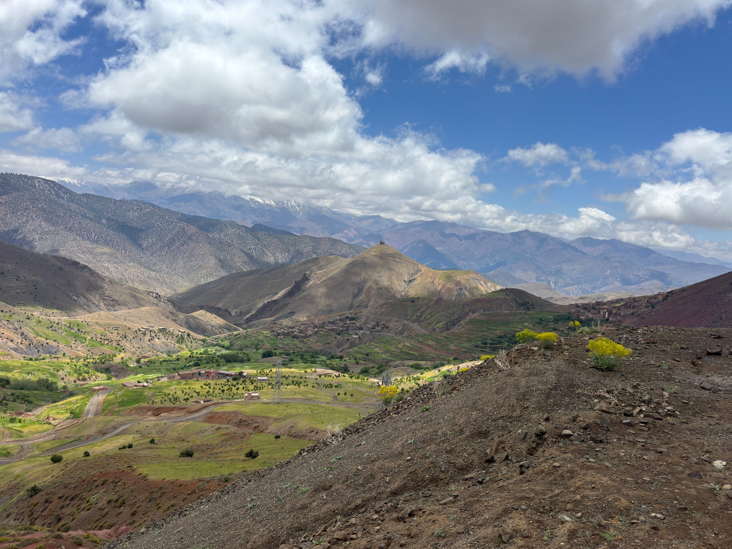 Breathtaking view of the Atlas Mountains under a cloudy sky, showcasing natural beauty and lush valleys.
